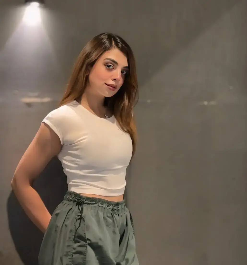 Komal Pakistani escort profile on modern atrium steps